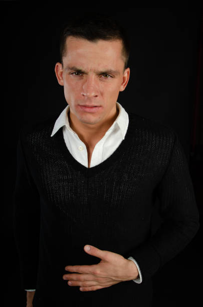 Headshot of attractive black haired young man outside, looking at camera