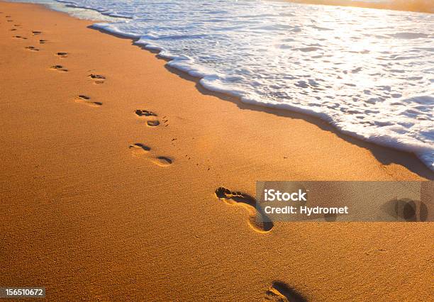 Beach Wave And Footsteps At Sunset Time Stock Photo - Download Image Now - Beach, Footprint, Coastline