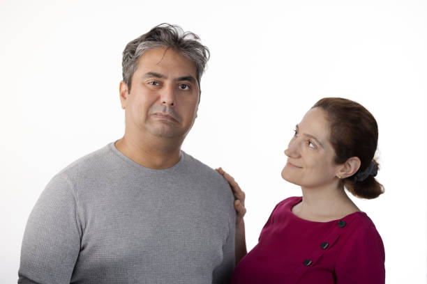 istock 40 year old Indian man with Tardive Dyskinesia looking at camera, caretaker providing support 1565130998