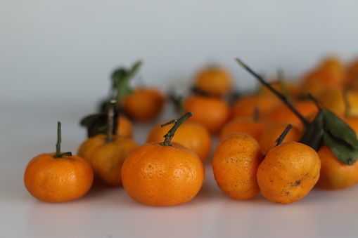 A bunch of Clementine fruit. It is a tangor, a citrus fruit hybrid between a willowleaf mandarin orange and a sweet orange. It has a deep orange colour and a smooth, glossy appearance