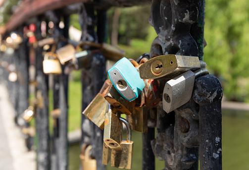 Railing on a bridge with locked padlocks of lovers. Close-up padlocks