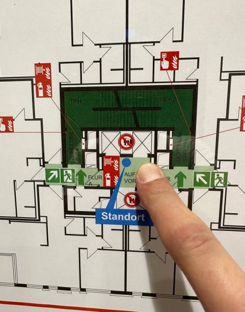 Finger pointing to current location on fire emergency evacuation plan
