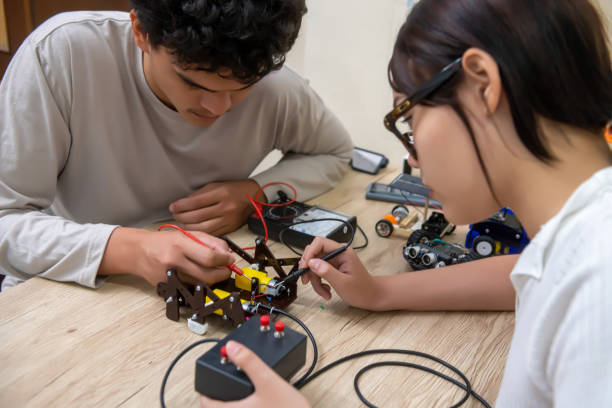istock Teenage students build learning with robotic vehicles at desks in STEM engineering science education classes. 1565204553