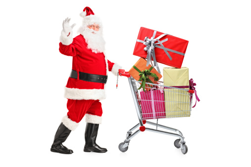 Santa Claus pushing a cart full of presents and waving hand isolated on white background