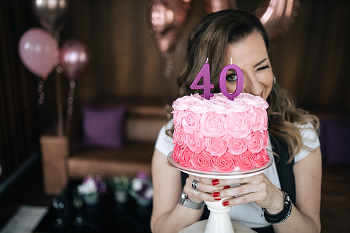 One woman, mature woman holding her 40th birthday cake.