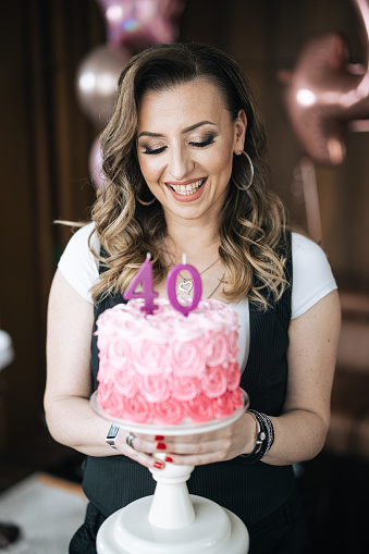 One woman, mature woman holding her 40th birthday cake.