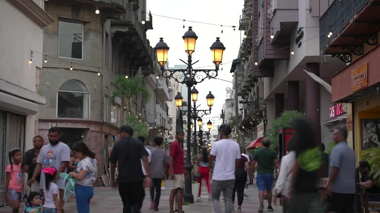 Dominican Republic, Santo Domingo - July 17, 2023: Timelapse of many people walk by Calle El Conde in Colonial City, lit by street lamps. Top things to do for tourists in the capital.