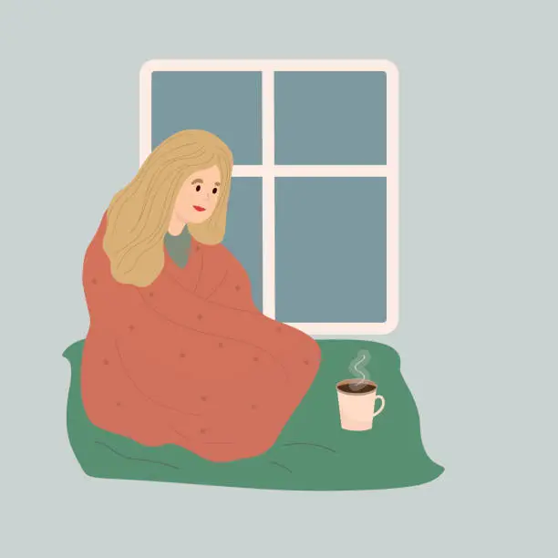 Vector illustration of Woman wrapped in cozy blanket is sitting next to teacup on plaid. Warm blanket in the interior with window. Vector illustration.