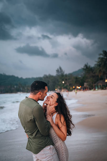 Side view of a young couple sharing love and affectionate on the beach.