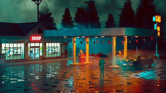 Moody cinematic scene with a man holding an umbrella and wearing trench coat, while he stands next to a retro gas station at night. There are puddles of rain water on the ground. The gas station is open and a sign is lit with the words 