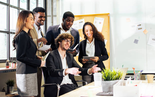 istock Diverse and multiracial smart businesspeople wearing formal suits, using computer, discussing by teleconference, brainstorming idea for company marketing plan in indoor modern office. 1565295781
