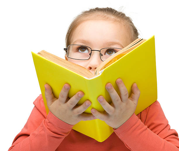 istock Little girl is dreaming while reading book 156534176