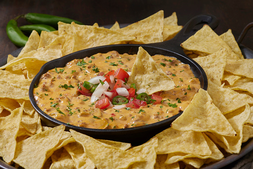 Deluxe Queso dip with Spicy Ground Beef, Onions, Tomatoes, Jalapeno's and Tortilla Chips