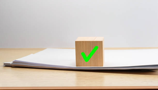 istock check mark positive sign on wooden cube with papers 1565404377