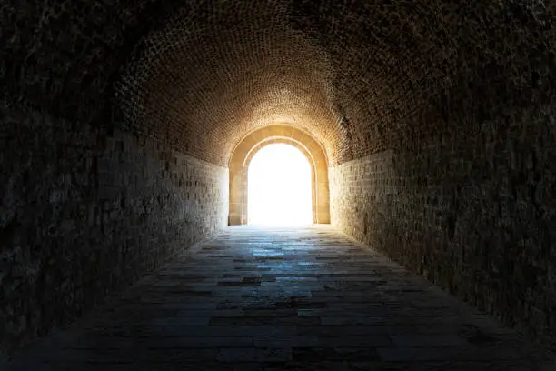 Photo of light at the end of the tunnel. dark tunnel in the catacomb