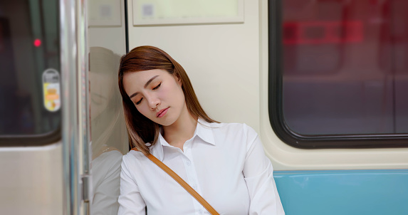 asian business woman is sleeping while commuting on metro mrt car