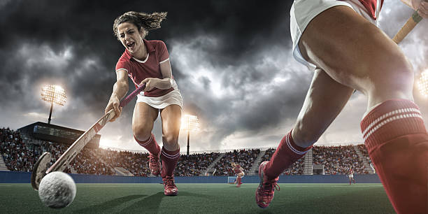 Extreme Close Up Field Hockey Action close up action image of field hockey players during professional match in floodlit stadium under dramatic stormy sky field hockey stock pictures, royalty-free photos & images