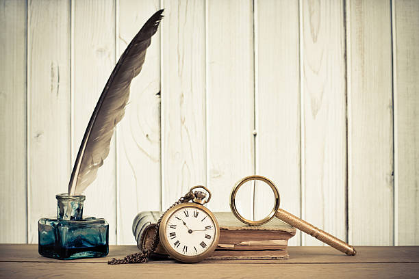 istock Quill pen, inkwell, book, magnifying glass on table 156547559