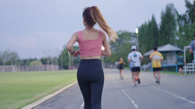 Multiple people jogging on a track field