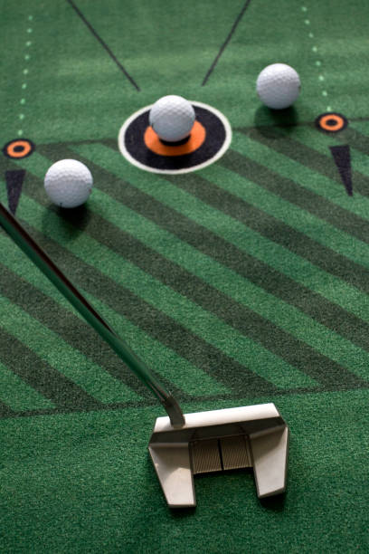 istock Indoor putting with putter and golf balls on practice mat 1565484949