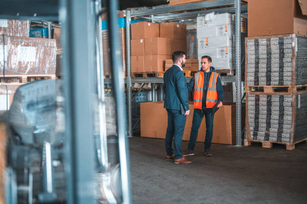 istock Two Men Standing And Talking In A Warehouse 1565499836