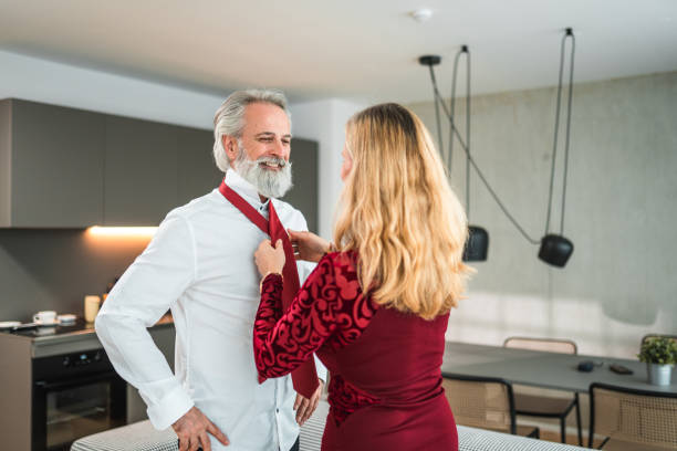 istock Mature Caucasian Male Getting Help Tying His Necktie At Home 1565502014