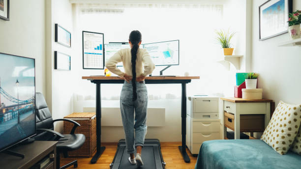 istock Woman at home office is walking on under desk treadmill 1565504732