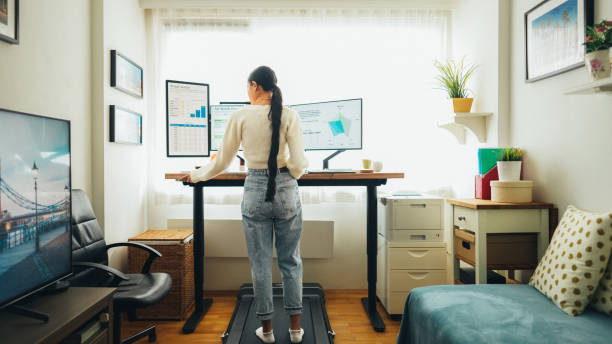 istock Woman at home office is walking on under desk treadmill 1565505267