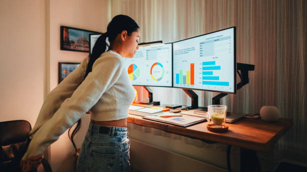 istock Woman working late at standing desk 1565506391