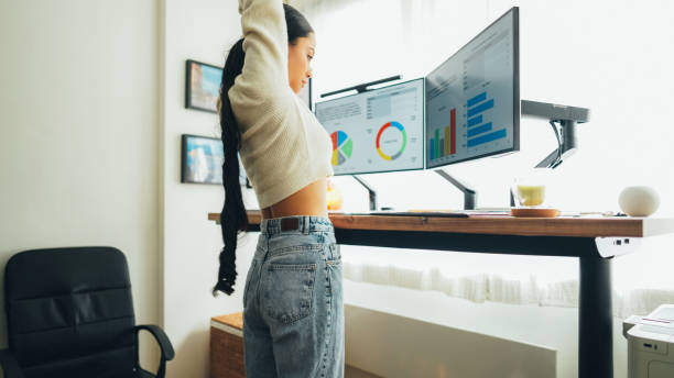 istock Woman at standing desk is working at home 1565506928