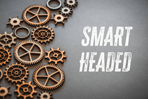 istock Smart Headed, small precise mechanisms, gears like clockwork, And text on a beautiful gray background, Smart Headed, The concept of development and creative operation of the company 1565573427
