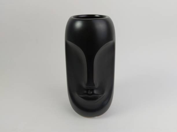 istock Closeup of a  black Vase with a face on a white background 1565573438