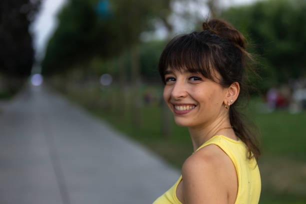 istock Pretty young lady is smiling at public park. 1565601366