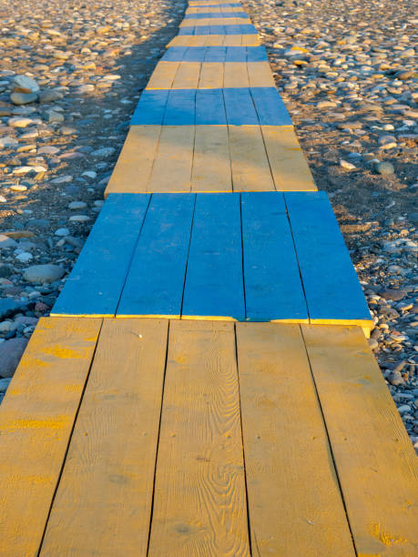 istock Yellow-blue flooring. Boardwalk to the beach. 1565635624
