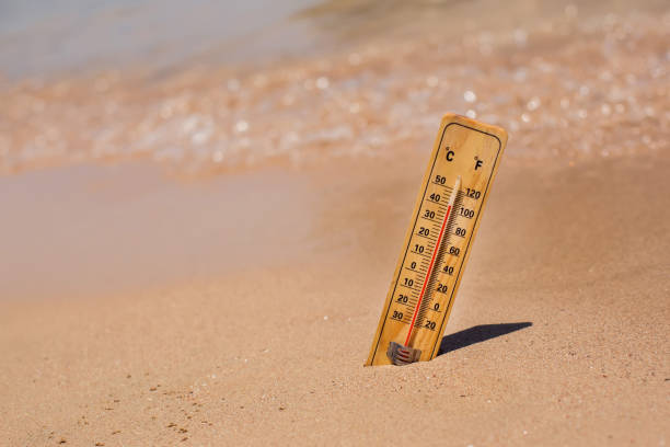 istock Thermometer on sand showing high temperature. Hot weather and climate concept 1565681656