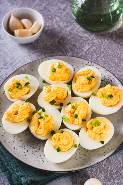 istock Boiled eggs stuffed with yolk, cheese, garlic and mayonnaise on a plate vertical view 1565682170