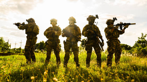 istock Smart teamwork of soldiers running forward and attacking enemy during military operation, Army soldiers in protective combat uniform, Soldiers with rifle, Soldiers with rifle on world war field 1565684315