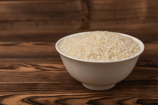 Healthy food. A bowl of steamed rice on  background. Place for text, copy space. Diet porridge.