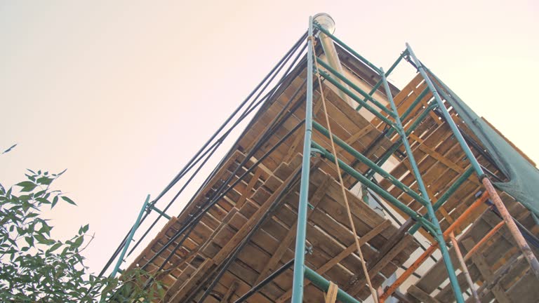 Wooden board grounds on high scaffolds near old building