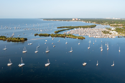 Miami, Florida; July 8, 2023. Aerial view of boats moored off Dinner Key Marina in Coconut Grove on calm clear cloudless summer morning.