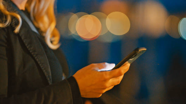 istock Woman using smart phone during vacation at night 1565713721