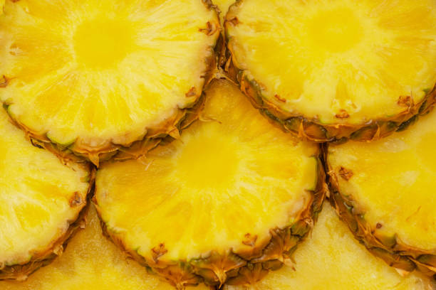istock Pineapple juicy yellow slices as a background. 1565725082