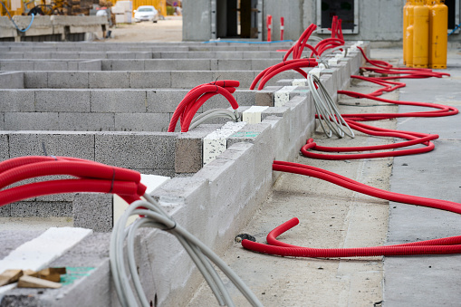Cables in red tubes to hide in wall or floor under concrete