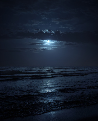 Moon over blue sea or ocean. Night view. A good background for the theme of travel, vacation, voyage.