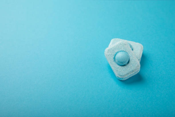istock Water softener tablets on a colored background, flat lay. Space for text.Capsules for washing machines and dishwashers that prevent limescale. Place to copy. 1565738954