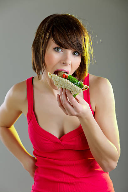 istock Young woman biting fresh sandwich 156578050