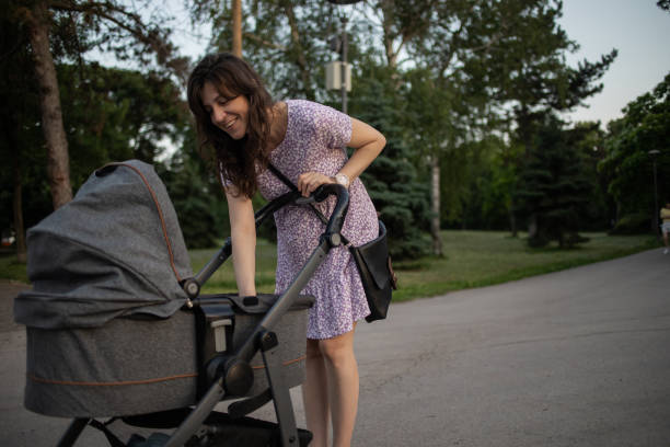Gray baby stroller at sunset on the sidewalk. Baby boy stroller in the park.