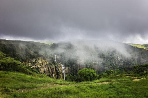 The water Fall in the mountain with Fogg and dark clouds in the sky