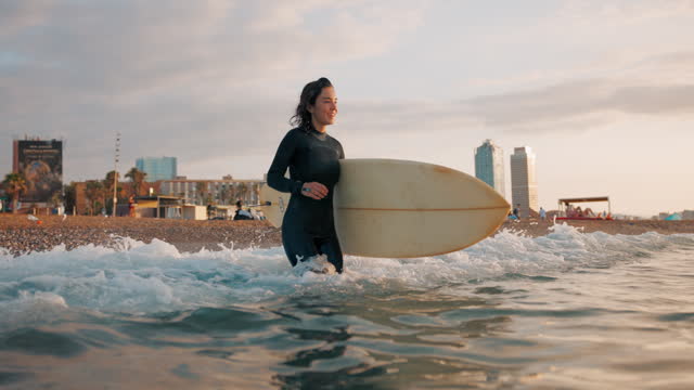 Young Female Surfer Excited Entering The Sea To Start To Surf