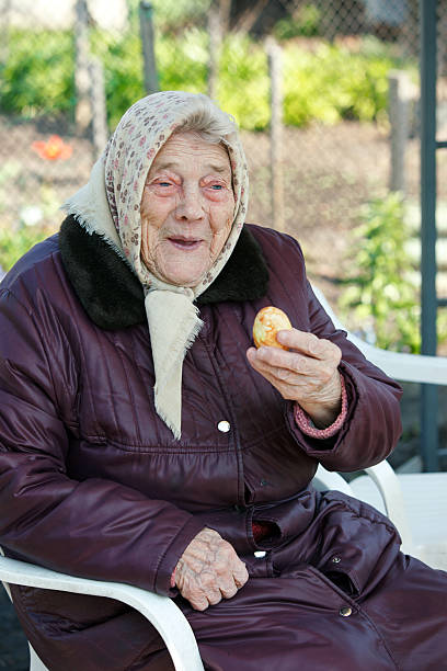 sorridente senior lady con uovo di pasqua dipinte - aging process affectionate vitality awe foto e immagini stock